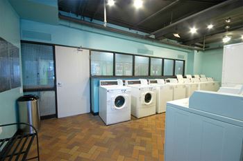 a washer and dryer room with a row of washing machines